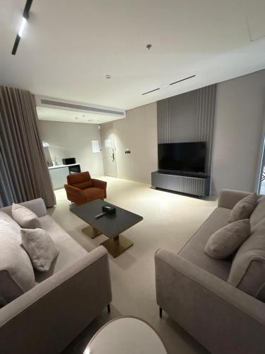 a living room with two couches and a flat screen tv at ودق للشقق المخدومة in Riyadh