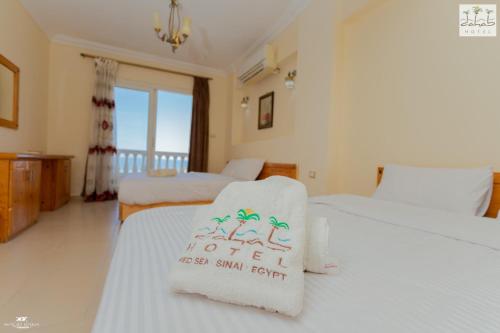 ein Hotelzimmer mit zwei Betten und einem Schild darauf in der Unterkunft Dahab Hotel in Dahab