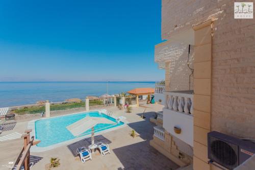 Blick auf einen Swimmingpool und das Meer von einem Gebäude aus in der Unterkunft Dahab Hotel in Dahab