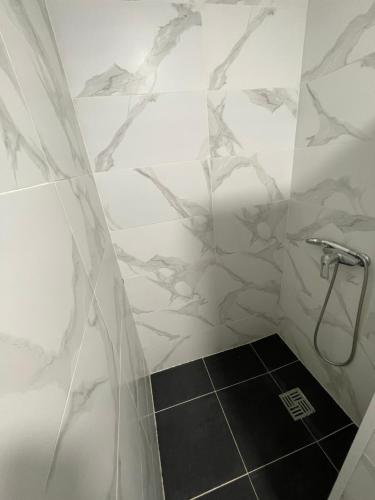 a bathroom with a shower with white marble walls at Отель Переулок средний 16 in Kropyvnytskyi
