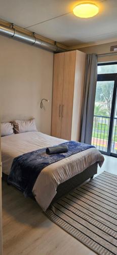 a bedroom with a large bed and a large window at Astros Lodge in Cape Town