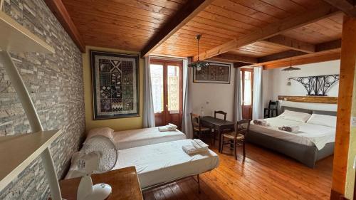 a bedroom with two beds in a room with wooden ceilings at B&B Muggianeddu in Tonara