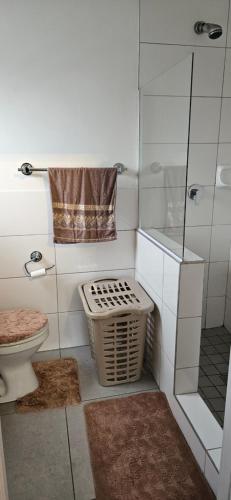 a bathroom with a toilet and a glass shower at Astros Lodge in Cape Town