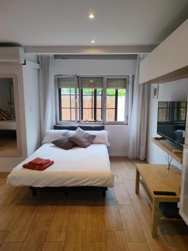 a bedroom with a large white bed with a window at Apartamentos Almenada in Llanes