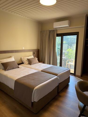 due letti in una camera d'albergo con finestra di Pine Inn a Spilia