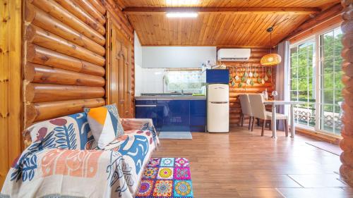 a living room with a couch and a kitchen at Pocheon Arumdri Pension in Pocheon