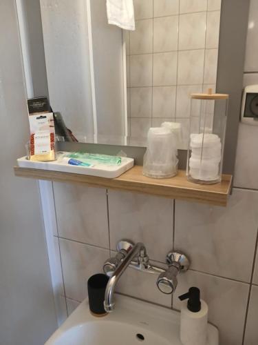 a bathroom with a sink and a mirror and a toilet at Willa Lazur in Władysławowo