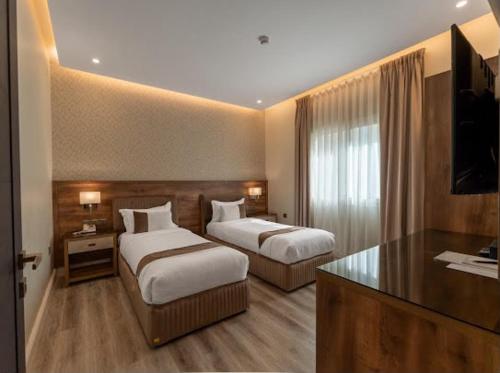 a hotel room with two beds and a television at Marmara Boutique in Medina