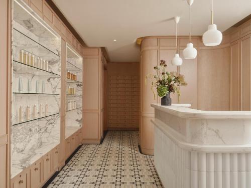 a hallway with a counter and a shelf with flowers at Hotel Kämp in Helsinki