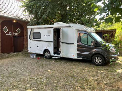 a black and white caravan parked in front of a garage at Gästehaus Schinna in Stolzenau