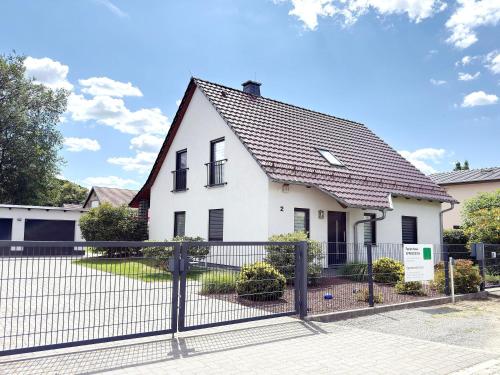 a white house with a black roof and a fence at Spreedeich in Werben