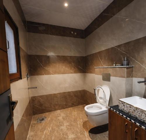 a bathroom with a toilet and a sink at Aravali view Farmhouse in Gurgaon