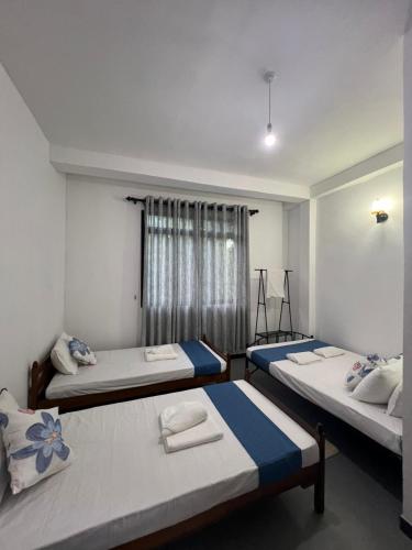 a bedroom with two beds and a window at Kandy Green Nature Villa in Kandy