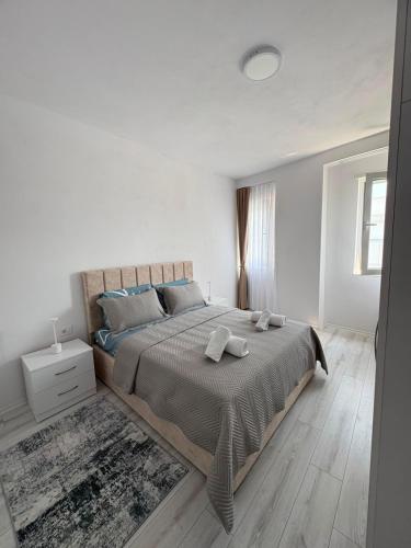 a white bedroom with a large bed and a window at Best House Albania in Kamëz