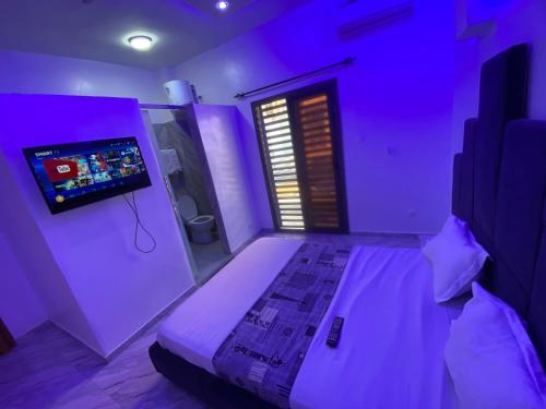 a purple room with a bed and a tv at Studio moderne in Saly Portudal