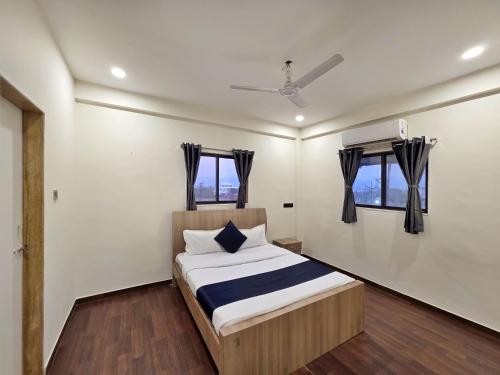 a bedroom with a bed and two windows at II EMPYREAN STAYS II WHITE PANTHER VILLA II 3BHK II AC II PRIVATE POOL ll in Lonavala
