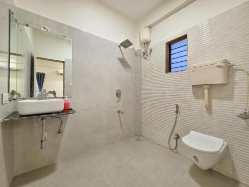 a bathroom with a sink and a toilet and a mirror at II EMPYREAN STAYS II WHITE PANTHER VILLA II 3BHK II AC II PRIVATE POOL ll in Lonavala
