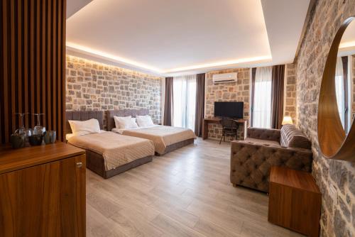 a bedroom with a bed and a couch and a tv at Agape Rose in Tivat