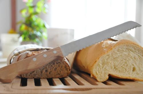 a knife on a cutting board with a loaf of bread at Albergo Rondò in Acqui Terme