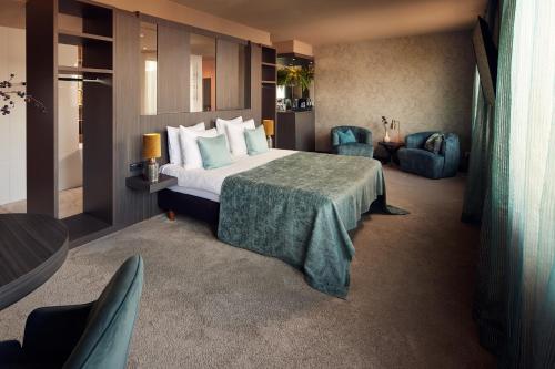 a hotel room with a bed and a table and chairs at Van der Valk Hotel Amersfoort-A1 in Amersfoort