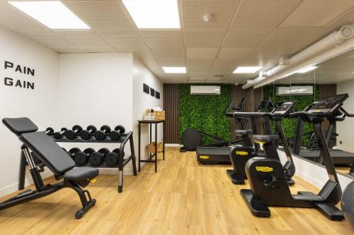 a gym with treadmills and exercise equipment in a room at Europe Hotel Paris Eiffel in Paris