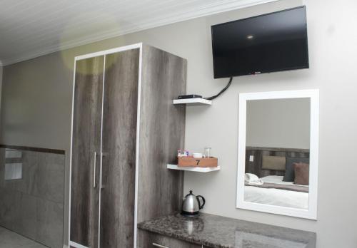 a bathroom with a tv on the wall and a mirror at The Hank Bethlehem Pty Ltd in Bethlehem