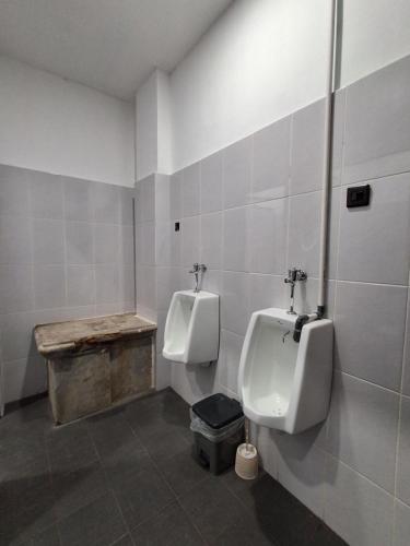 a bathroom with two urinals on the wall at Nglinteg Hostel in Yogyakarta