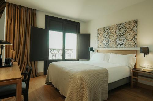 a hotel room with a large bed and a window at Hotel Estepona Plaza in Estepona