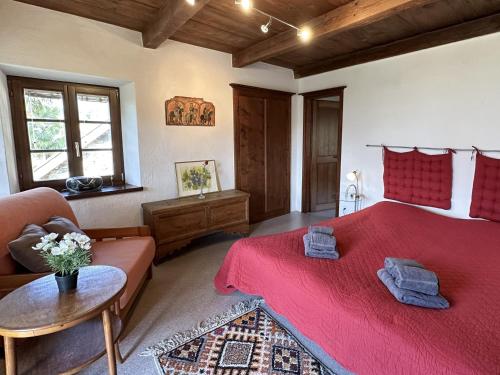 a bedroom with a red bed and a couch at Al Torchio by Fewotessin in Riazzino