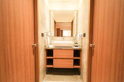 a bathroom with a sink and a mirror at MGM Vailankanni in Velankanni