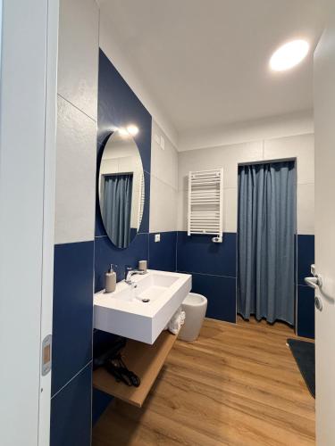 ein Badezimmer mit einem weißen Waschbecken und einer blauen Wand in der Unterkunft Cascina del colle - Casa Briè in Villamagna
