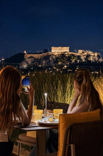 two women sitting at a table looking at the acropolis at St George Lycabettus Lifestyle Hotel in Athens