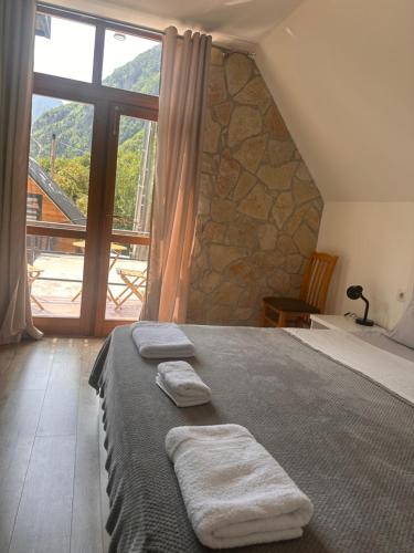 a bedroom with a bed with three towels on it at Petriti theth in Theth