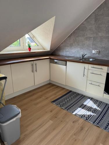 a kitchen with white cabinets and a sink and a window at Casa Blanca in Schwanau