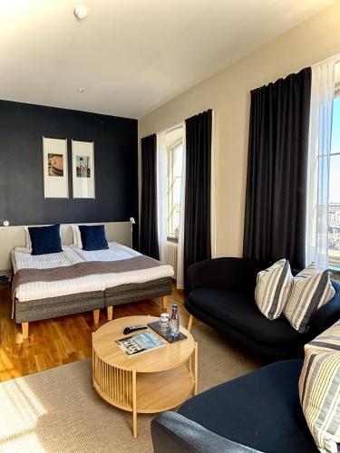a living room with a bed and a couch at Maritim Hotell & Krog in Simrishamn