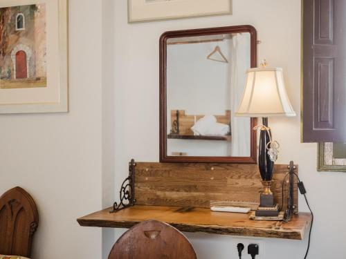 a mirror and a lamp on a wooden table at La Casa 1832 Boutique in Sanlúcar de Barrameda