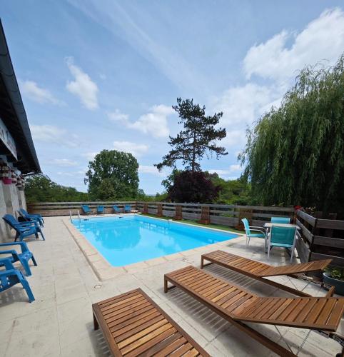 a swimming pool with chairs and a table at Le Fenelon in Carennac