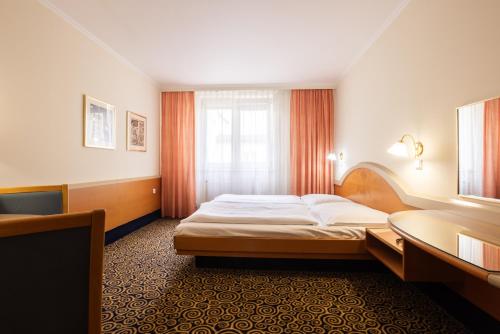 ein Hotelzimmer mit einem Bett und einem Fenster in der Unterkunft Hotel Eroplán in Rožnov pod Radhoštěm