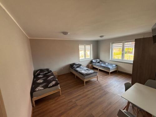 an empty room with two beds and two windows at Noclegi Antoniewo in Morąg
