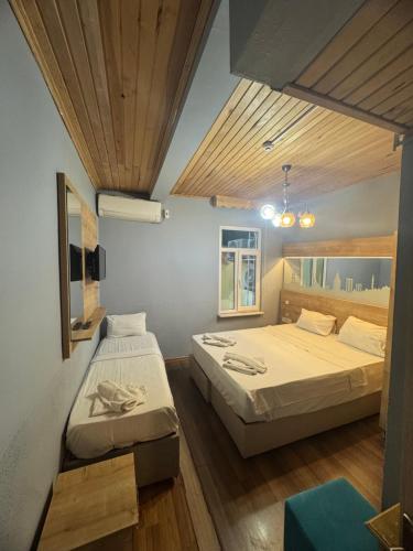 two beds in a room with wooden ceilings at Hotel Megaron in Istanbul