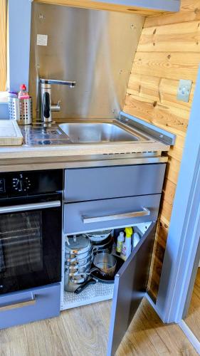 a kitchen with a sink and an open oven at Herons Rest Pod By The Sea in Morar Station