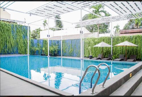 a swimming pool with chairs and umbrellas in a building at Grand Central Medan in Medan