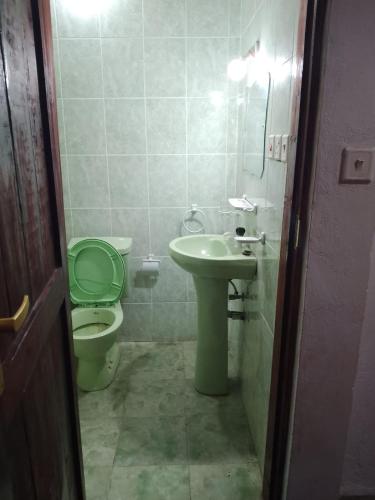 a small bathroom with a toilet and a sink at Al Mar Bed and Breakfast in Watamu