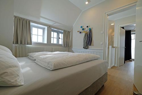 a bedroom with a large white bed in a room at An der See in Dranske