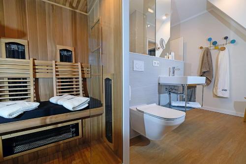 two pictures of a bathroom with a toilet and a sink at An der See in Dranske