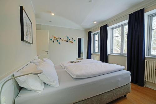 a bedroom with a bed with white sheets and pillows at Auszeit am Meer in Dranske