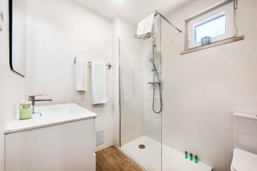 a white bathroom with a shower and a sink at Villa Mar Gale in Galé