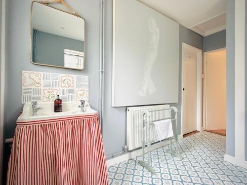 a bathroom with a sink and a mirror on the wall at The Cottage at Cobbolds Mill in Monks Eleigh