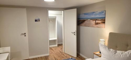 a bedroom with a door open to a room with a bed at White Coast Villa in Grömitz