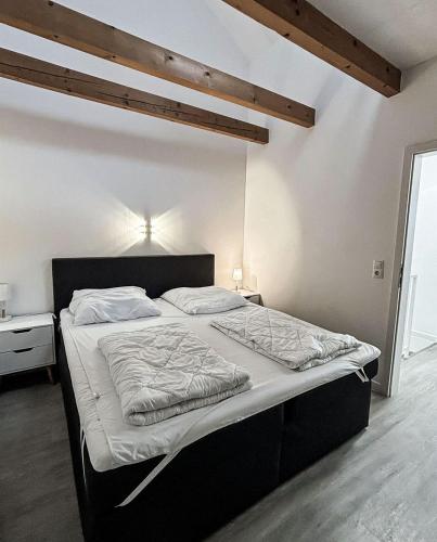 a bedroom with a large bed with white sheets at Bugoase in Dranske